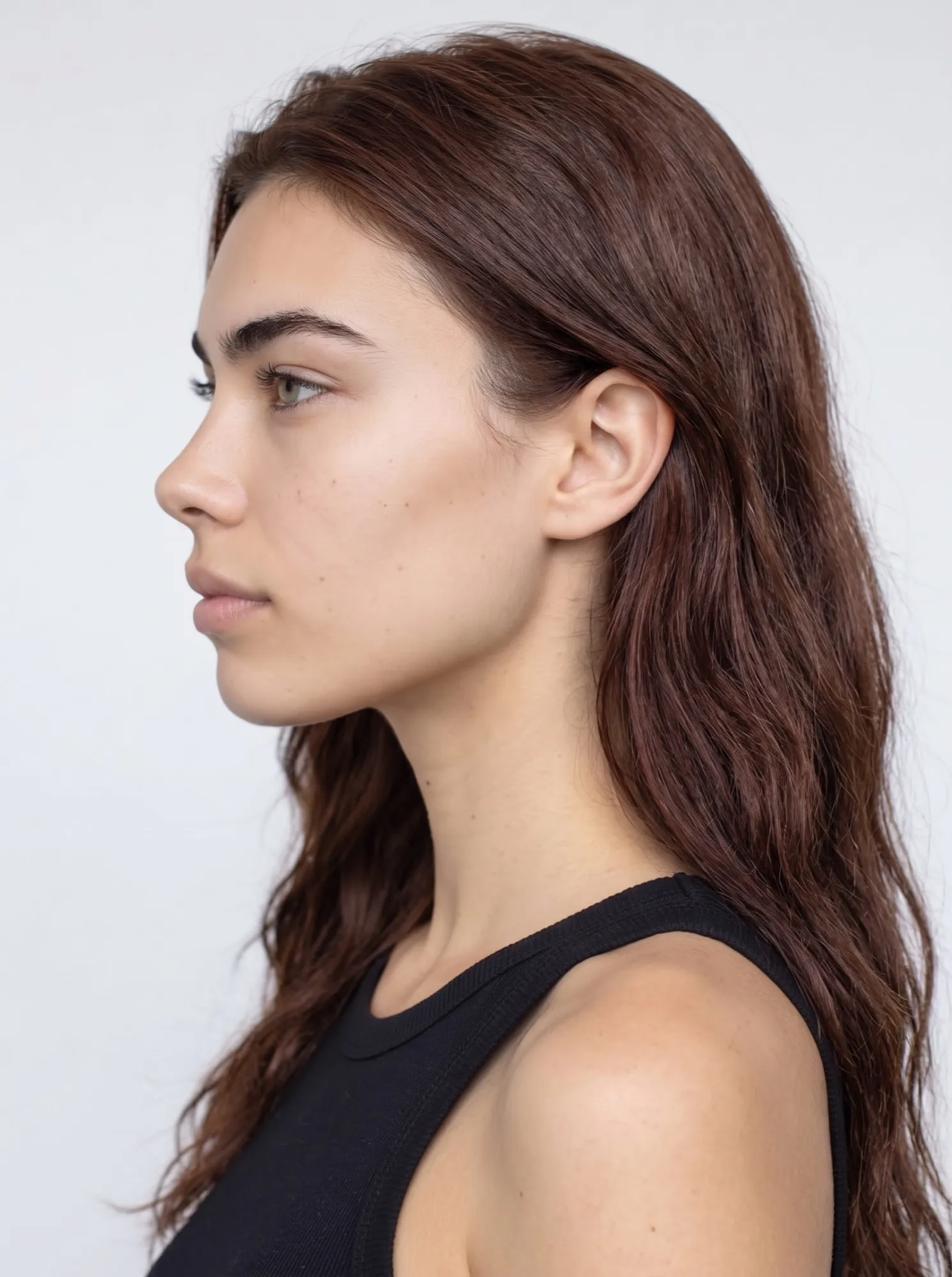 The model in side profile, auburn hair falling past the shoulder