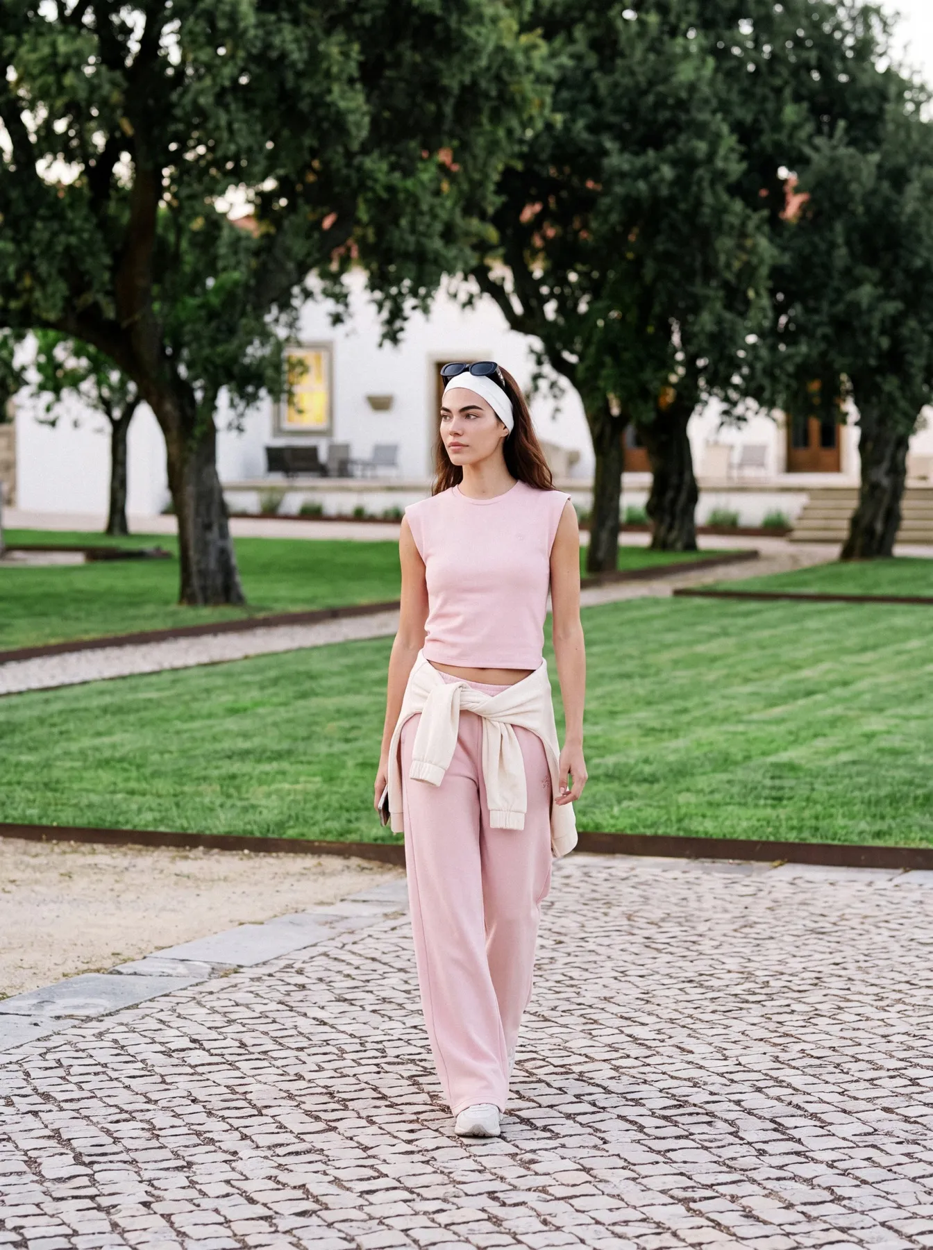 Model in pink walking the cobbled path between the lawns